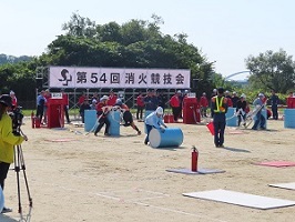 写真　消火競技会　ドラム缶を転がす様子