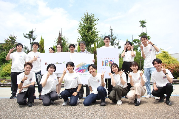 写真：学生らとともにロゴマークを披露する豊田市長