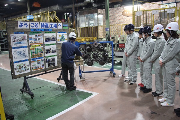 写真：鋳造について説明を受ける豊田高専の学生