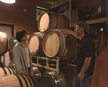 ワイン樽の前に立つ須崎さんご夫婦