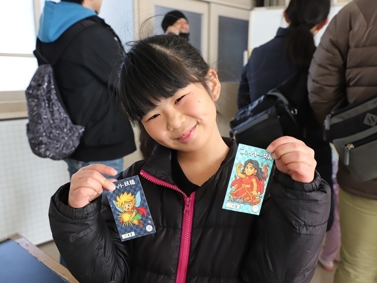 謎解きクイズにクリアし、景品のカードをもらった子ども