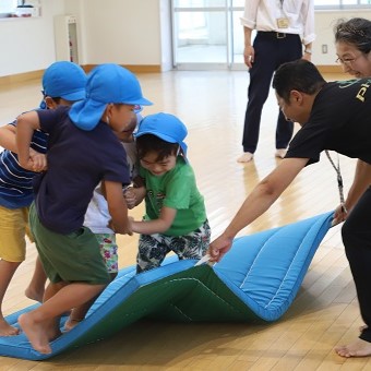写真：講師の指導で運動遊びをする児童たち
