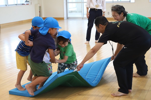 写真：講師の指導で運動遊びをする児童たち
