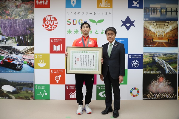 写真説明：記念撮影を行う川口選手と市長