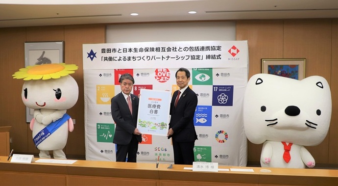 写真説明： 協定書を持つ日本生命の清水会長・松村支社長と太田市長