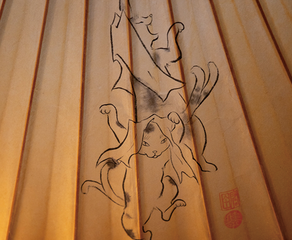 岡田さんが自身の愛猫をモチーフにして和傘に筆入れした図案