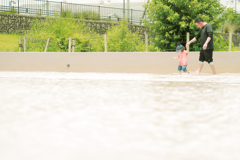 写真:中央公園のじゃぶじゃぶ池で遊ぶ親子