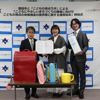 写真説明： 協定書を持つこどもの視点ラボの石田共同代表・沓掛共同代表と太田市長