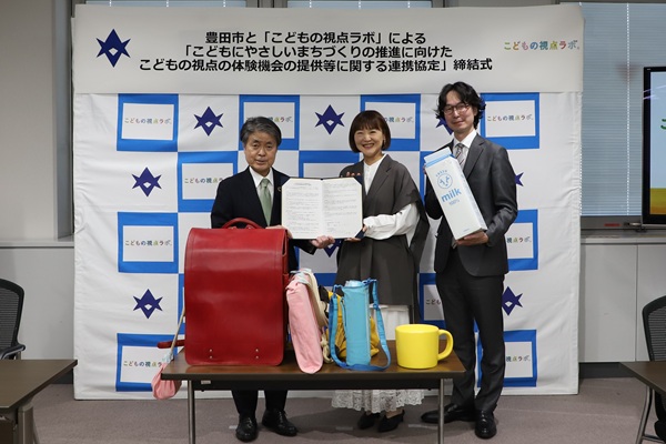 写真説明： 協定書を持つこどもの視点ラボの石田共同代表・沓掛共同代表と太田市長