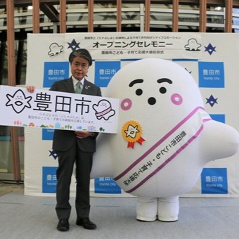 写真説明：記念撮影を行う市長とぷしゅぷしゅ