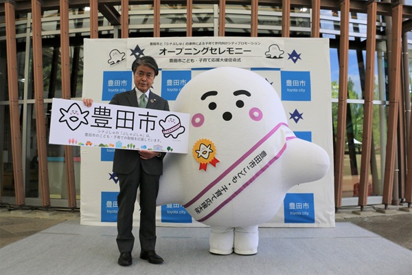 写真説明：記念撮影を行う市長とぷしゅぷしゅ