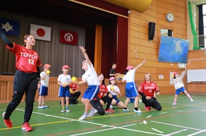 写真説明:講師の指導でボール投げに取り組む児童たち