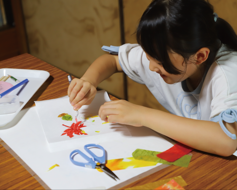 写真:季節のタペストリーの和紙を貼り付けている様子