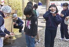 写真：萩野小の児童が地域の人と「醤油搾り」に挑戦
