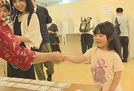 写真：「親子連れ投票」の投票記念証の配布